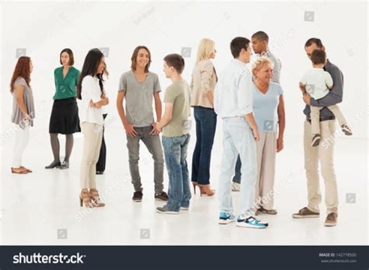 a group of people standing next to each other in front of a crowd holding signs