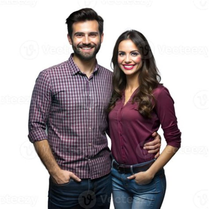 a man and woman standing next to each other in front of a red carpeted
