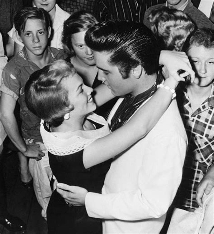 Elvis shares a hug with girlfriend Anita Wood before he boards a train